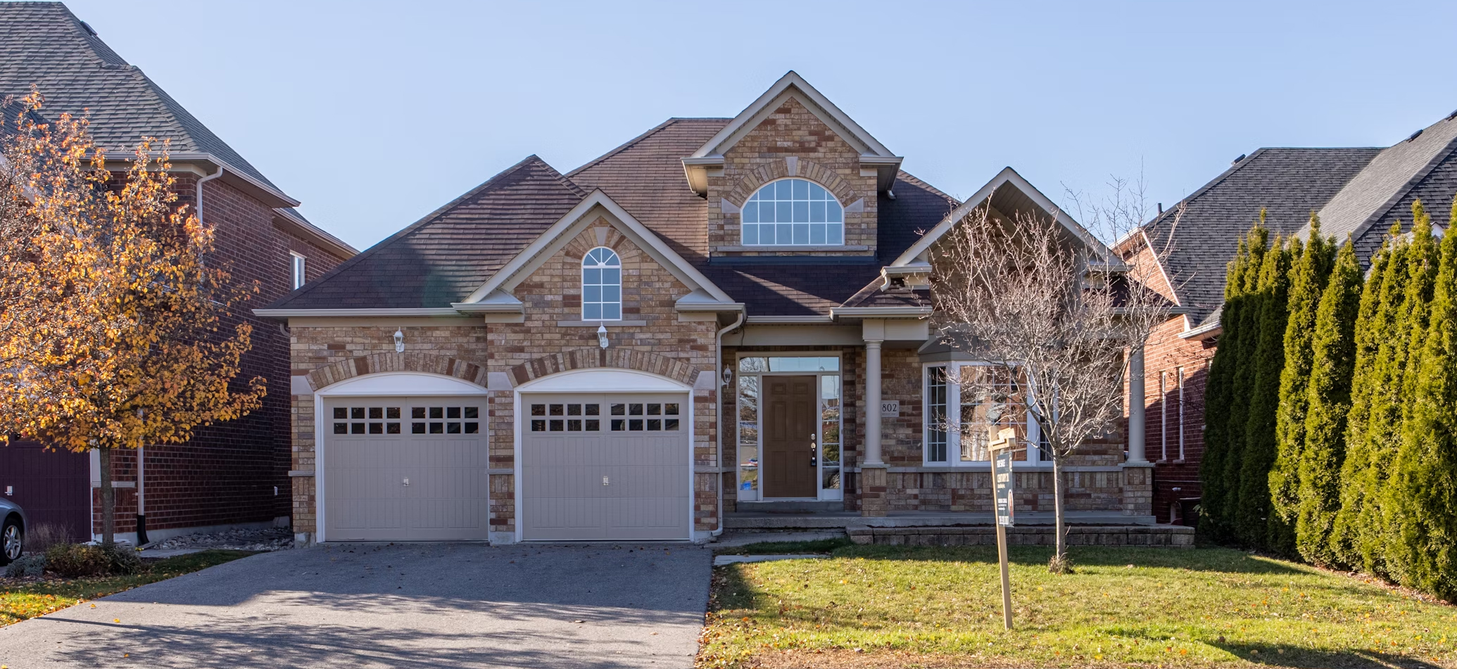 Garage door opener repair service in Santa Ana, CA, featuring a residential home with two garage doors and a well-maintained lawn.